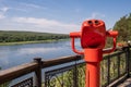 Public stationary binoculars on the banks of the river in summer