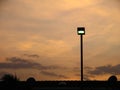 Public street lighting and sunset in the background. Royalty Free Stock Photo