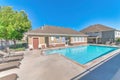 Public swimming pool with office building and relaxing outdoor lounge chairs Royalty Free Stock Photo