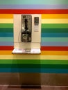 Public telephone booth on a rainbow colored wall at the Changi Airport in Singapore