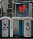 Public toilet cabins in the street of Dusseldorf in front of a building with Gemeinsam stark logo