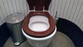 The public toilet is cleaned with a wooden toilet seat