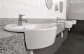 Public toilet counter top complete with basins, water taps, and face mirror. Royalty Free Stock Photo