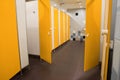 Public toilet interior with bright yellow stalls