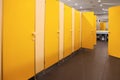 Public toilet interior with bright yellow stalls