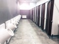 Public toilet restroom with doors and urinals in a row Royalty Free Stock Photo
