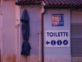 Public toilet and signs on it. A sign with information about a public toilet. WC
