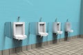 Public toilets with white porcelain urinals in line