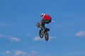 Public training in a public park. A brave biker jumps very high on a motorcycle and performs a stunt.