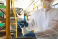 Public transport sanitation. Worker in suit disinfecting bus salon, focus on hand with spray bottle