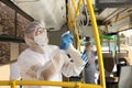 Public transport sanitation. Workers in protective suits disinfecting bus