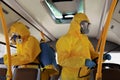 Public transport. Workers in protective suits disinfecting bus salon Royalty Free Stock Photo