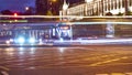 Public transportation in a city. Tram leaving the station, traffic lights, people, street, houses, overhead wires, rails. Movement