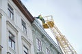 Public utilities on special vehicles remove icicles from the roofs of houses on the Rynok square in Lviv. Roof Winter Workers