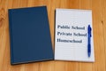 Public vs private vs homeschool schools with retro old blue book with notepad and pen