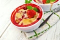 Pudding strawberry in two bowls on light board