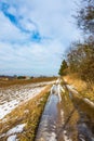 Puddle on the countryside road, near the field and farm. Royalty Free Stock Photo