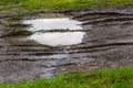 Puddle in dirt road at summer daylight - closeup with selective focus Royalty Free Stock Photo