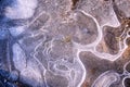 Puddle in the forest, covered with ice-abstract pattern of nature, close-up, copy space, toned.