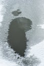 A puddle of meltwater on the lake. A puddle covered with a thin crust of ice and frost, snow. Frozen lake. Top view Royalty Free Stock Photo