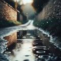 Puddles fill an empty country lane, as rain creates ripples in the water