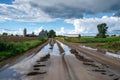 puddles forming on a dirt road with farm backdrop Royalty Free Stock Photo