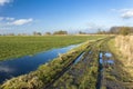 Puddles on a green field and rural road, white clouds on the blue sky Royalty Free Stock Photo