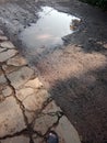 puddles on potholes asphalt road