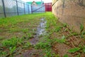 Puddles after rain near the wall of a wooden house Royalty Free Stock Photo