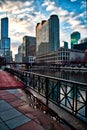 Puddles reflect cityscape in Chicago after a winter storm, as clouds clear and sun begins to set.