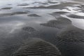 Puddles and undulations in the sand caused by the outgoing tide
