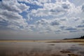 puddles of water on the beach reflecting the clouds of a very cloudy sky Royalty Free Stock Photo