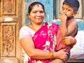 Cheerful mother with red saree with adorable young boy in the street of village. Dalit people so poor but smiling