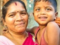 Cheerful mother with red saree with adorable young boy in the street of village. Dalit people so poor but smiling