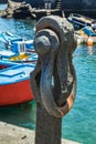 Puerto de la Cruz, Tenerife, Spain - July 10, 2019: Rust anchor in the Old port of town. Small fishing boats of local people.
