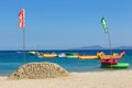 Puerto Galera - April 4, 2017: Sand castle with sign `Puerto Galera` on White beach with tourists and water activities on backgrou