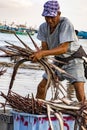 Puerto Lopez - August 19, 2016 - Fisherman sorts his catch of pipe fish into baskets Royalty Free Stock Photo