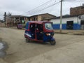 Puerto Lopez, Ecuador, 9-7-2019: a blue tuctuc driving down the road and the driver giving a thumbs up Royalty Free Stock Photo