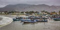 Puerto Lopez, Ecuador - September 12, 2018 - Fishermen finish their day fixing nets, cleaning boats, and talking with