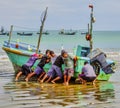 Puerto Lopez, Ecuador - September 12, 2018 - Six men work together to bring fishing boat onto the beach at the end of a Royalty Free Stock Photo