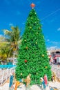 Puerto Morelos, Mexico - January 10, 2018: Outdoor view of a huge christmast tree with a manger in the base in the park Royalty Free Stock Photo