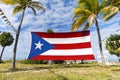 puerto rico Flag Among Palm. Puerto Rican flag against tropical palm trees and blue sky. Beautiful tropical landscape on the Royalty Free Stock Photo