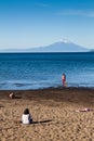 PUERTO VARAS, CHILE - MAR 23: People on a bach of Llanquihue lake in Puerto Varas town. Osorno volcano in the background Royalty Free Stock Photo