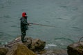 PUERTO VARAS, CHILE, SEPTEMBER, 23, 2018: Unidentified fisherman standing in a rock with a fishing rod on chilean