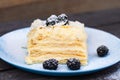 puff cake with blackberries on a blue plate on a wooden background Royalty Free Stock Photo