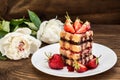 Puff cake with cream, chocolate and strawberry, on a wooden table. Close-up Royalty Free Stock Photo