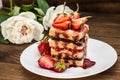 Puff cake with cream, chocolate and strawberry, on a wooden table. Close-up Royalty Free Stock Photo