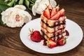 Puff cake with cream, chocolate and strawberry, on a wooden table. Close-up Royalty Free Stock Photo