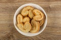 Puff cookies in heart shape in plate on wooden table. Top view