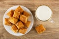 Puff cookies in white plate , cup with milk on wooden table. Top view